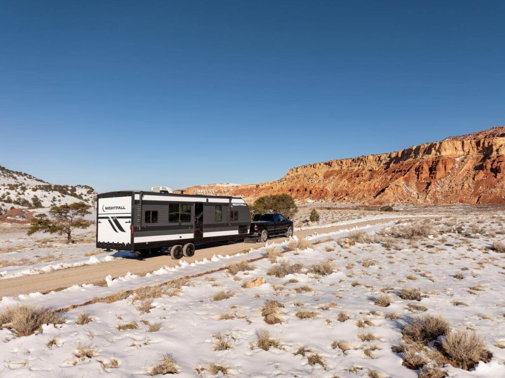 Nightfall toy hauler trailer being towed in snowy environment