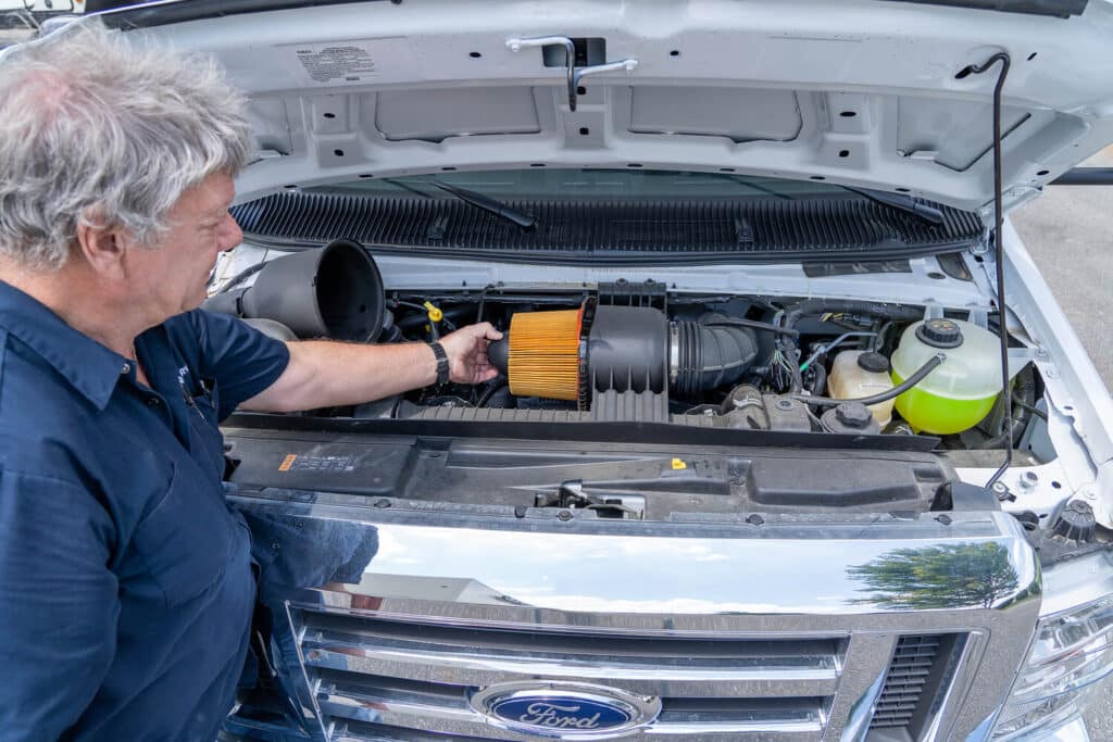Technician checking air filter in motorhome basic RV maintenance tips