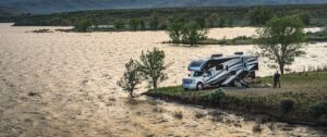 Thor Super C RV boondocking next to a lake