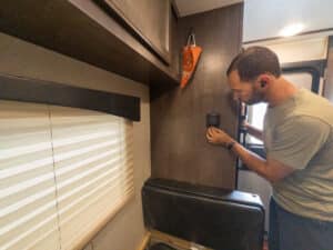 Man adjusting RV thermostat