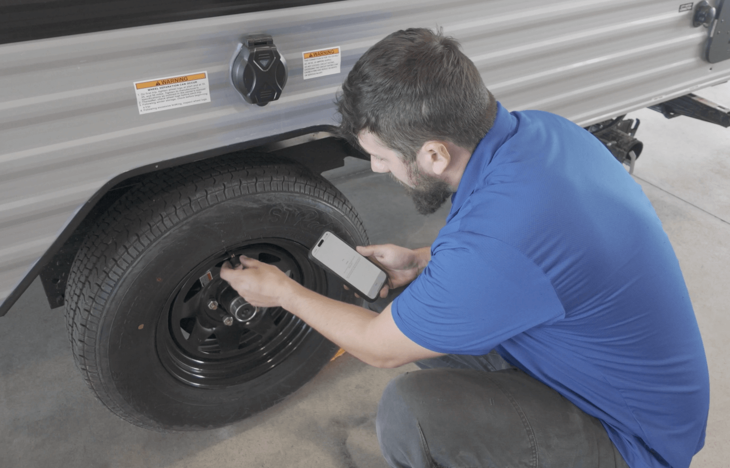 An RV tire and valve being checked during maintenance
