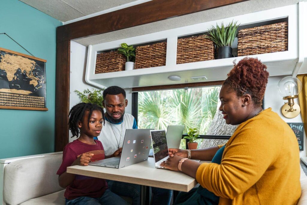 Family using multiple computers at RV dinette