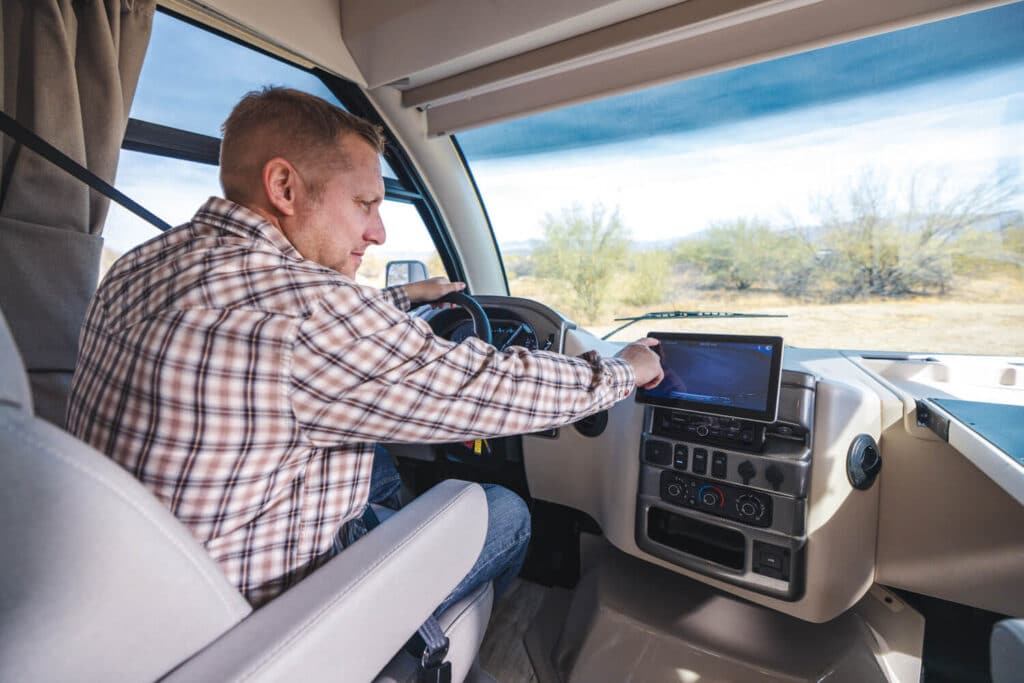Man touching dash display in motorhome