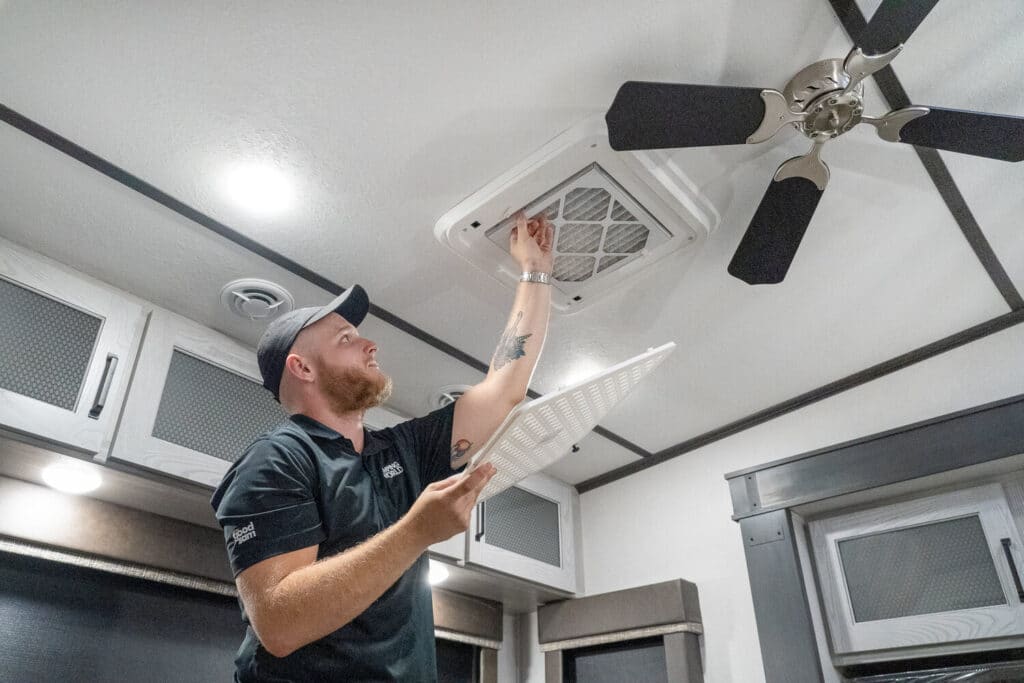 Technician removing filter from RV air conditioner