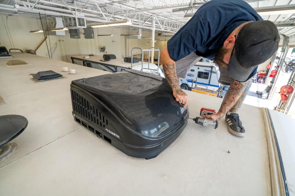 Technician removing RV AC shroud