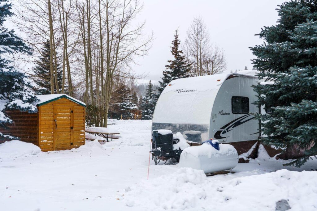 Travel trailer parked permanently with snow on the ground in winter