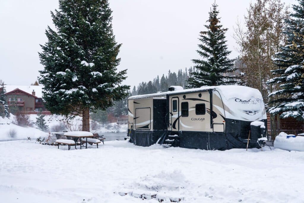 Cougar 4 season travel trailer in the snow with RV skirting