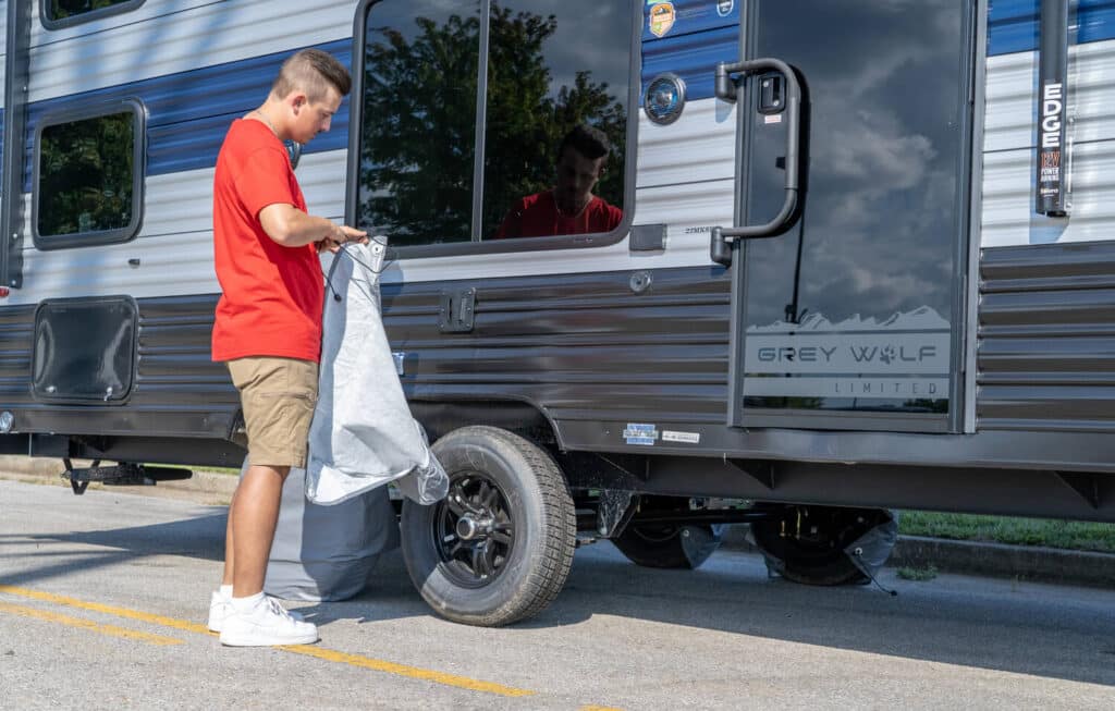 Man opening for tire on travel trailer