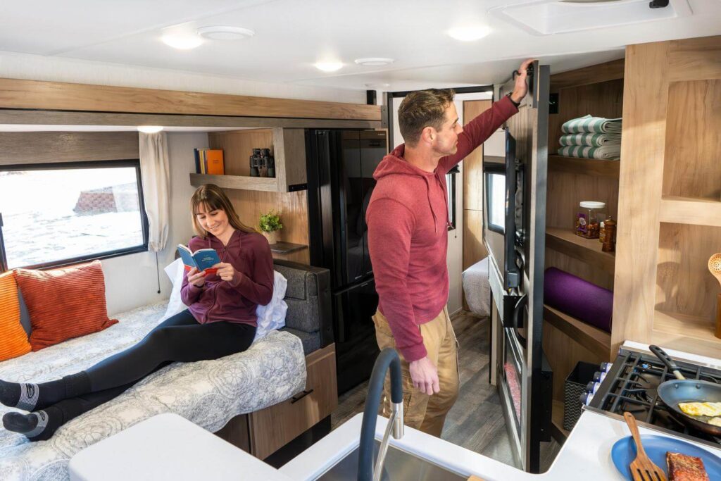 Man opening hidden storage pantry in travel trailer