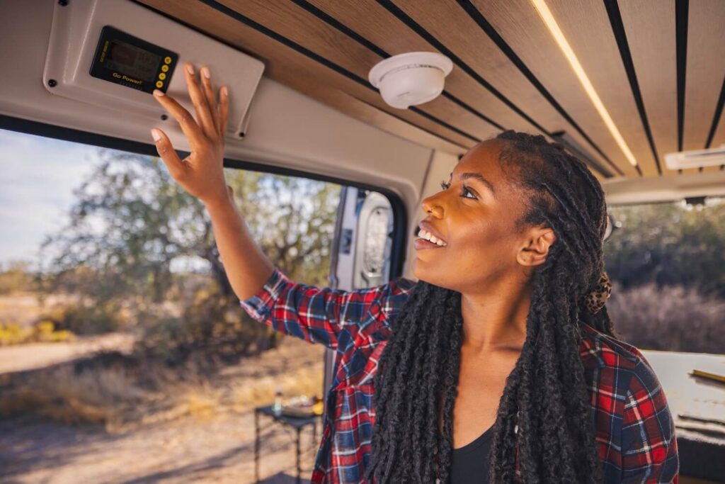 Woman inspecting the controls of her Class B RV. 