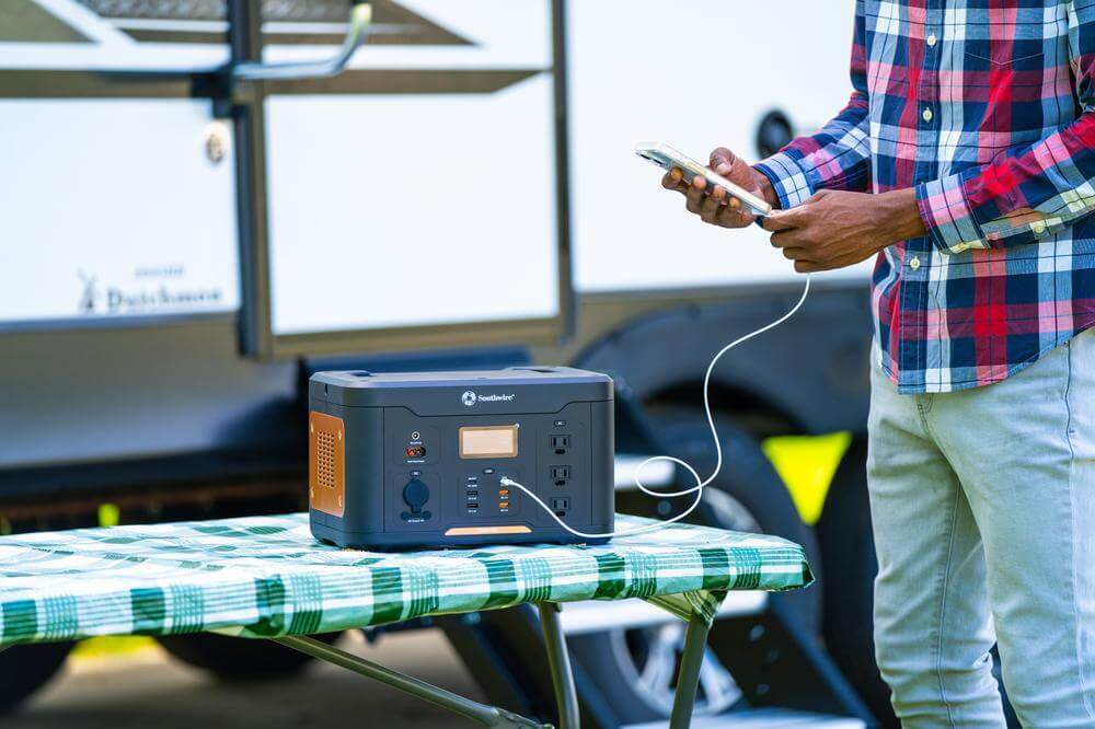 Man plugging phone into portable power station