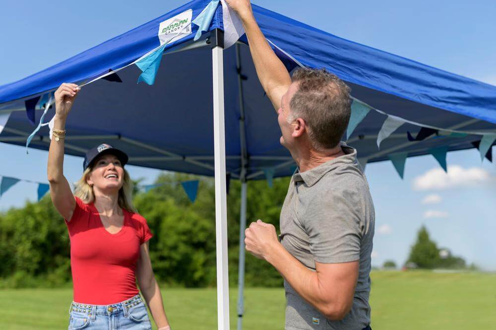 Couple setting up instant canopy shelter