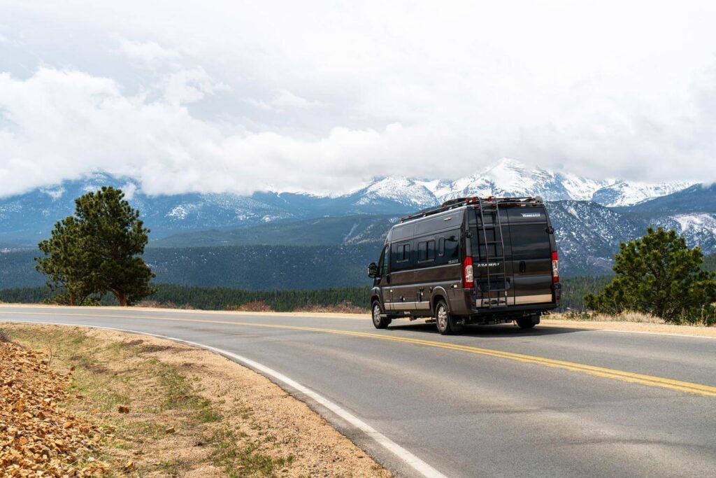 Winnebago Travato Class B RV driving with mountains in the background