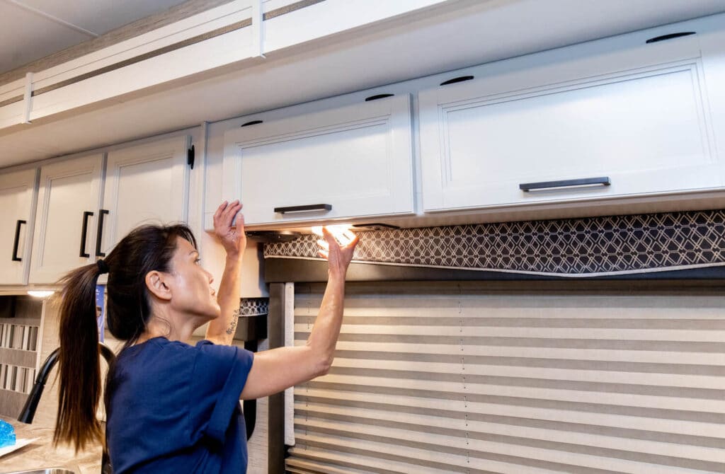 Technician inspecting lights for RV construction methods