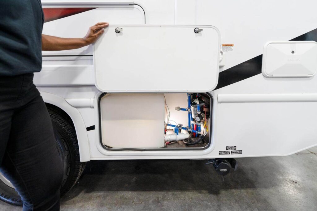 Technician inspecting a camper's plumbing