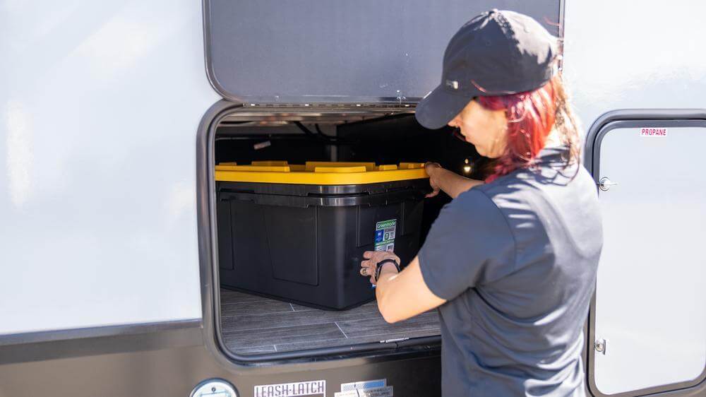 woman removing bins from camper storage