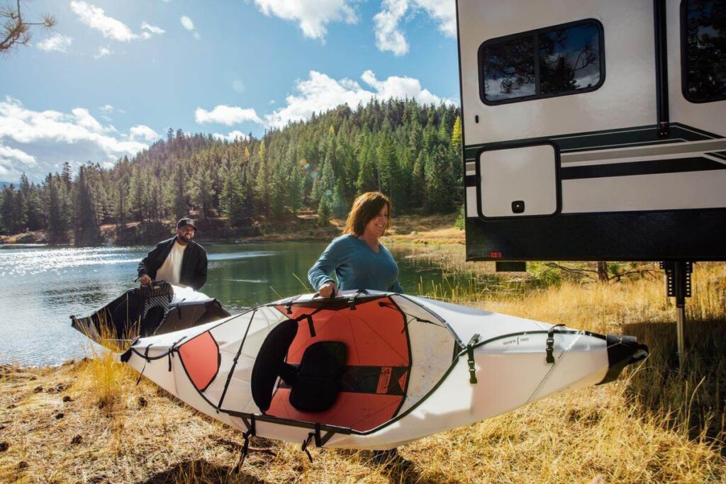 Pareja llevando kayaks Oru plegables