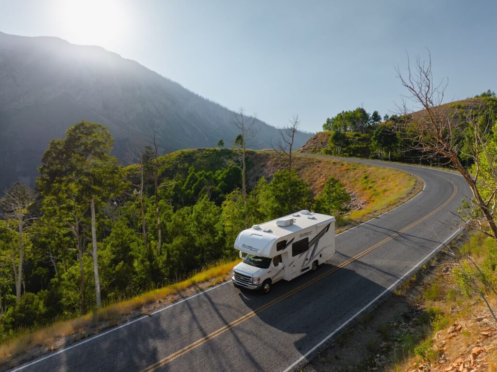 Class C RV driving down a mountain road