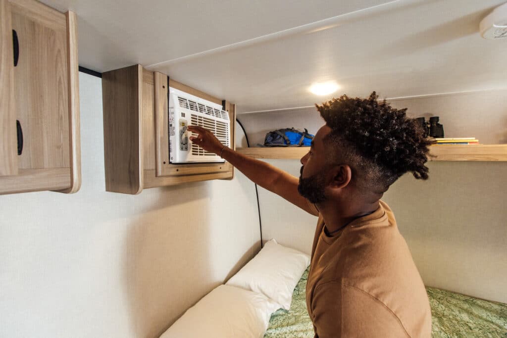 Man turning on air conditioner in camper
