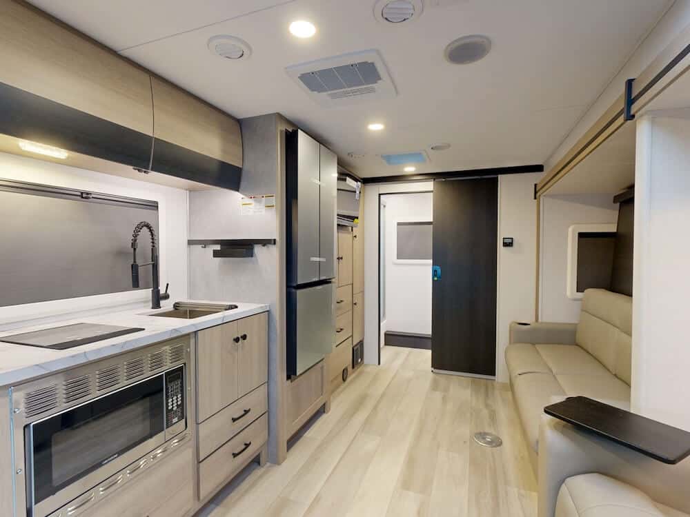 Interior image of the living room and galley kitchen for the Forest River Forester MBS 2401T Class C RV.
