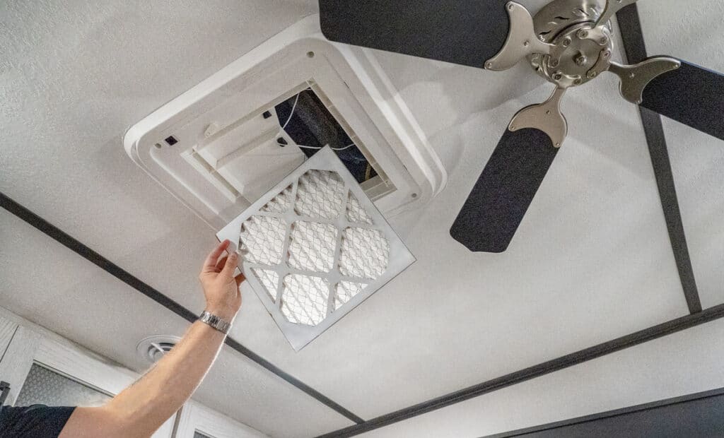 tech inspecting rv air conditioner filter