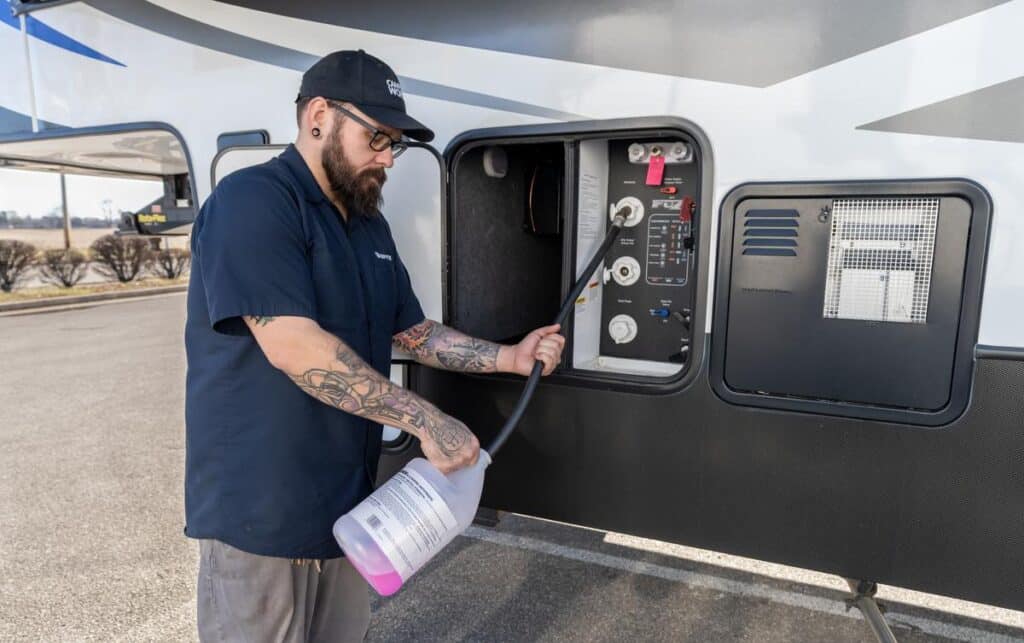 Professional technician winterizing a fifth wheel RV
