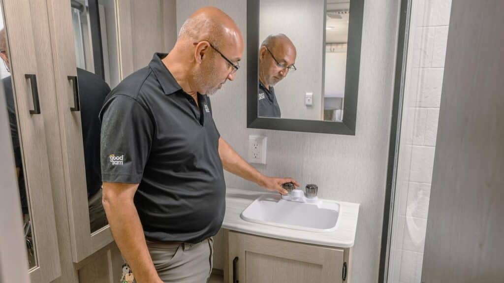 technician inspecting faucet inside camper