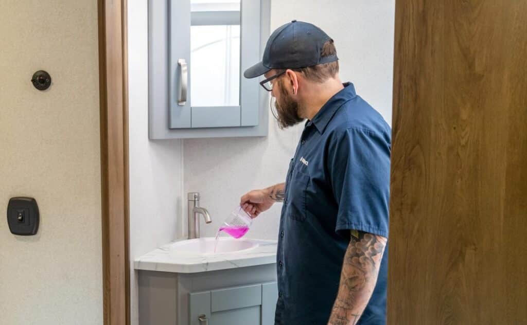 Certified technician performing RV winterization service